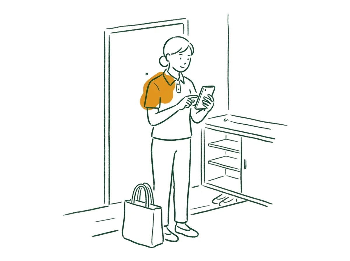 利用者様のお宅の玄関で、その場でスマートフォンに記録を入力するヘルパーのイラスト